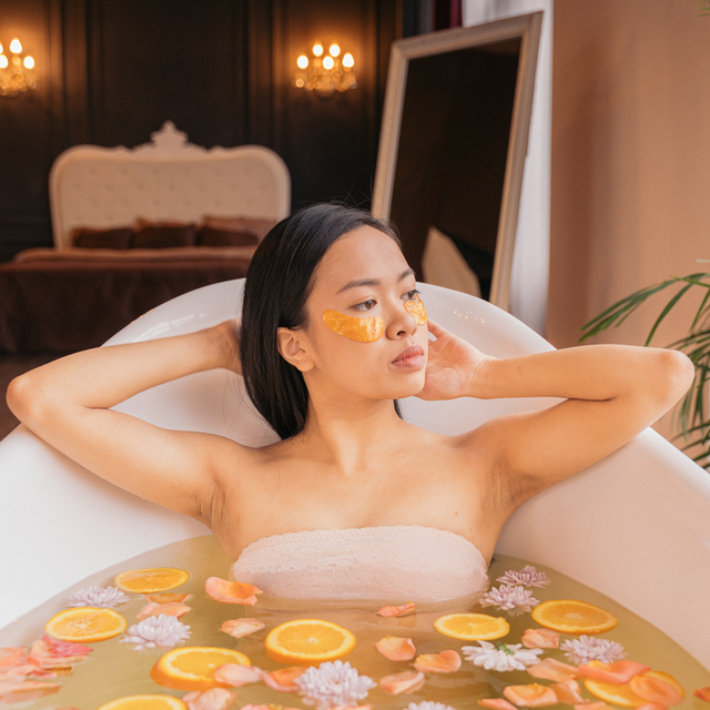 A woman in a bath with citrus and flowers after using lemon balm and lysine for herpes symptom help.