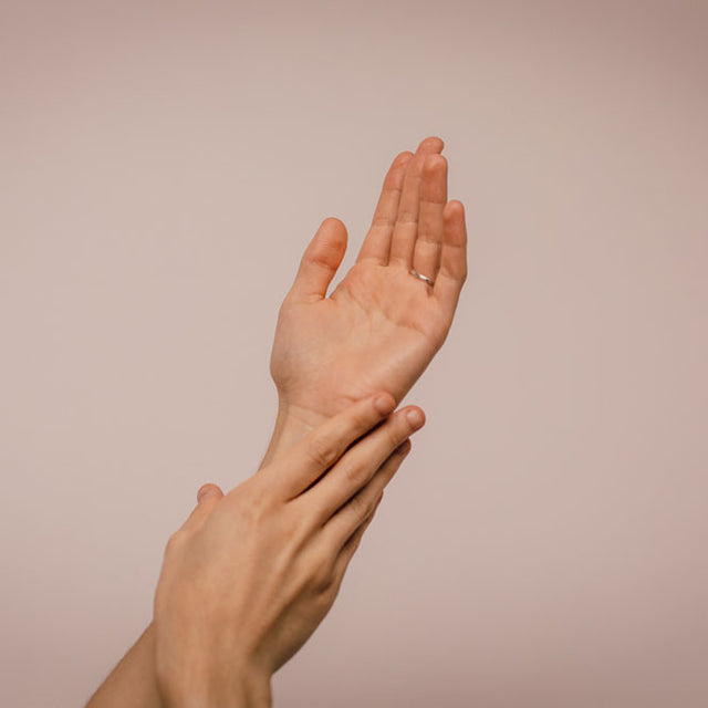 A woman holding up their hands and touching their skin. Doing whatever you consider to be self-care during a genital herpes outbreak is important.