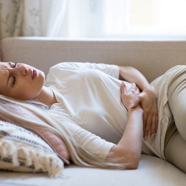woman laying in pain from a uti looking for at home otc uti treatments