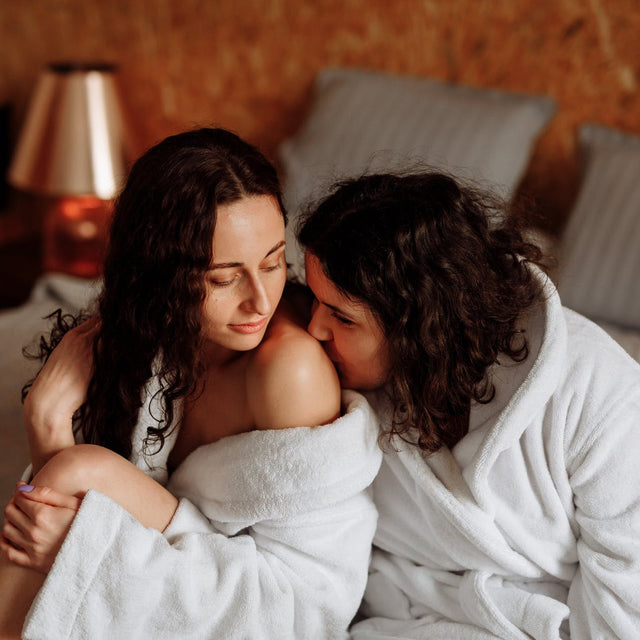 Two women sitting on a bed together