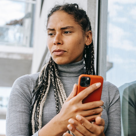 A woman with a towel on her head and smiling in a pink bathroom. Yeast Infection Facts vs. Fiction