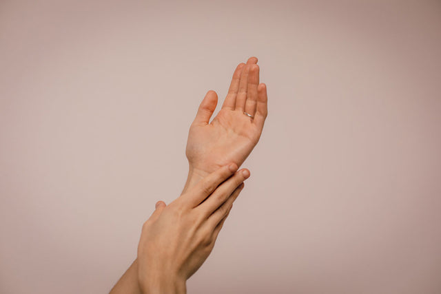 A woman holding up their hands and touching their skin. Doing whatever you consider to be self-care during a genital herpes outbreak is important.