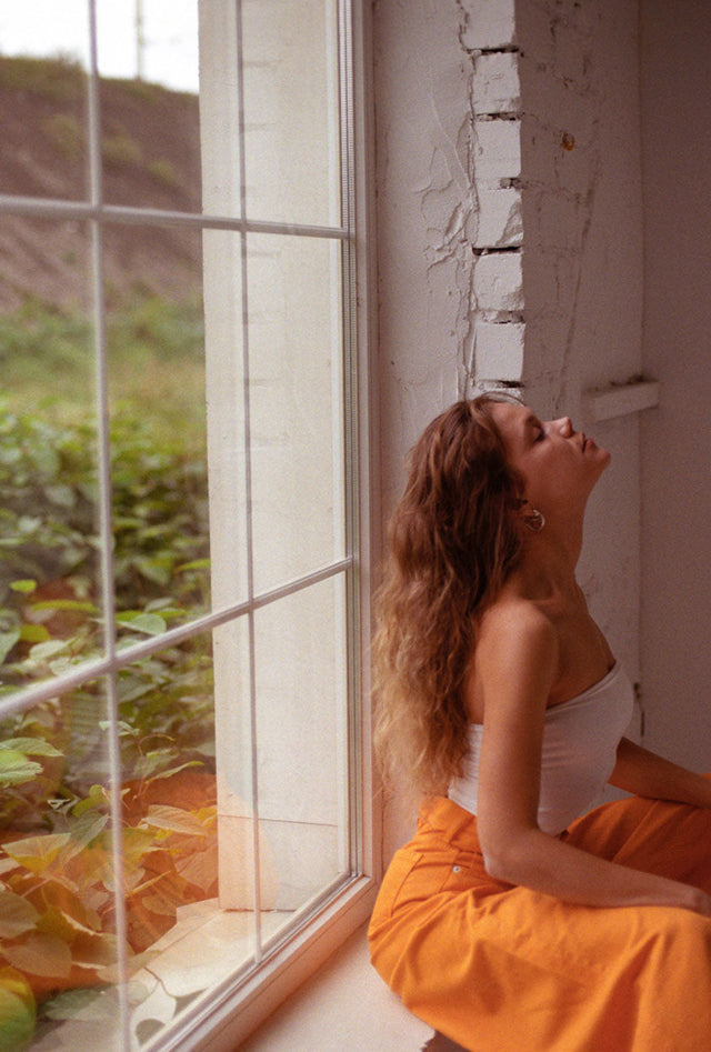 A woman practicing meditation outdoors to manage stress during a genital herpes outbreak.
