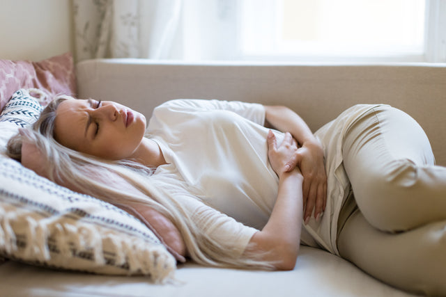 woman laying in pain from a uti looking for at home otc uti treatments