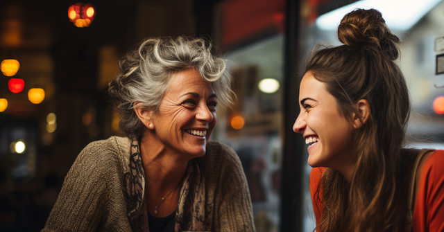 woman in her 60s laughs with woman in her 20s in restaurant