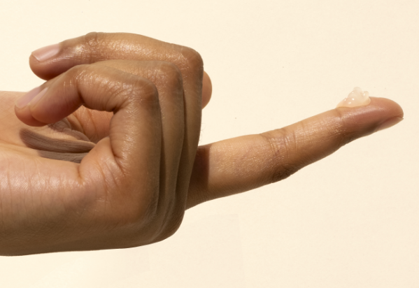 A hand with a pea sized drop of ointment